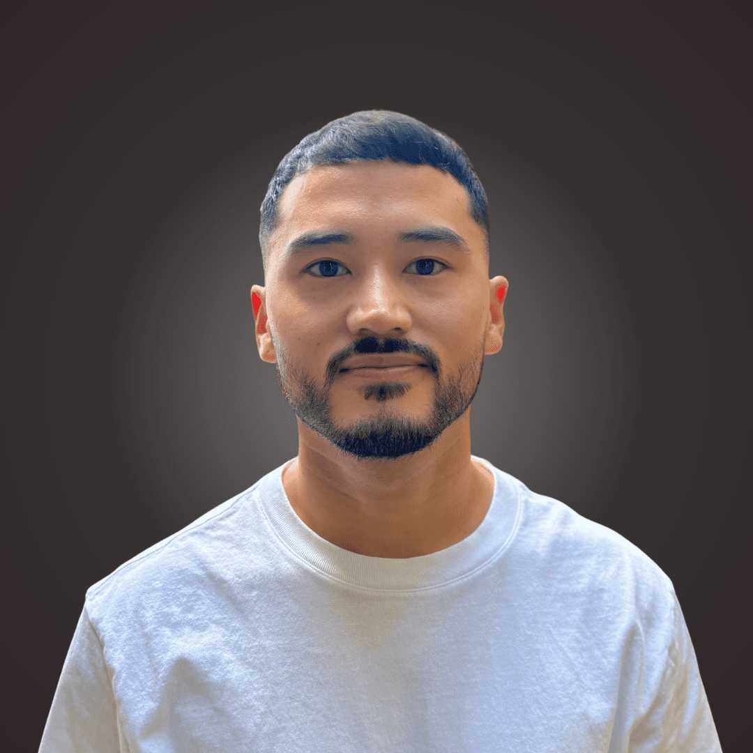 Headshot of Toma Matisoff in front of a black background with a soft glow coming from the center